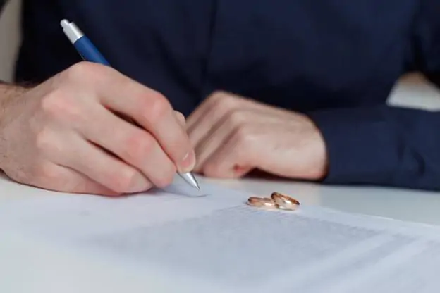 A man signing divorce documents